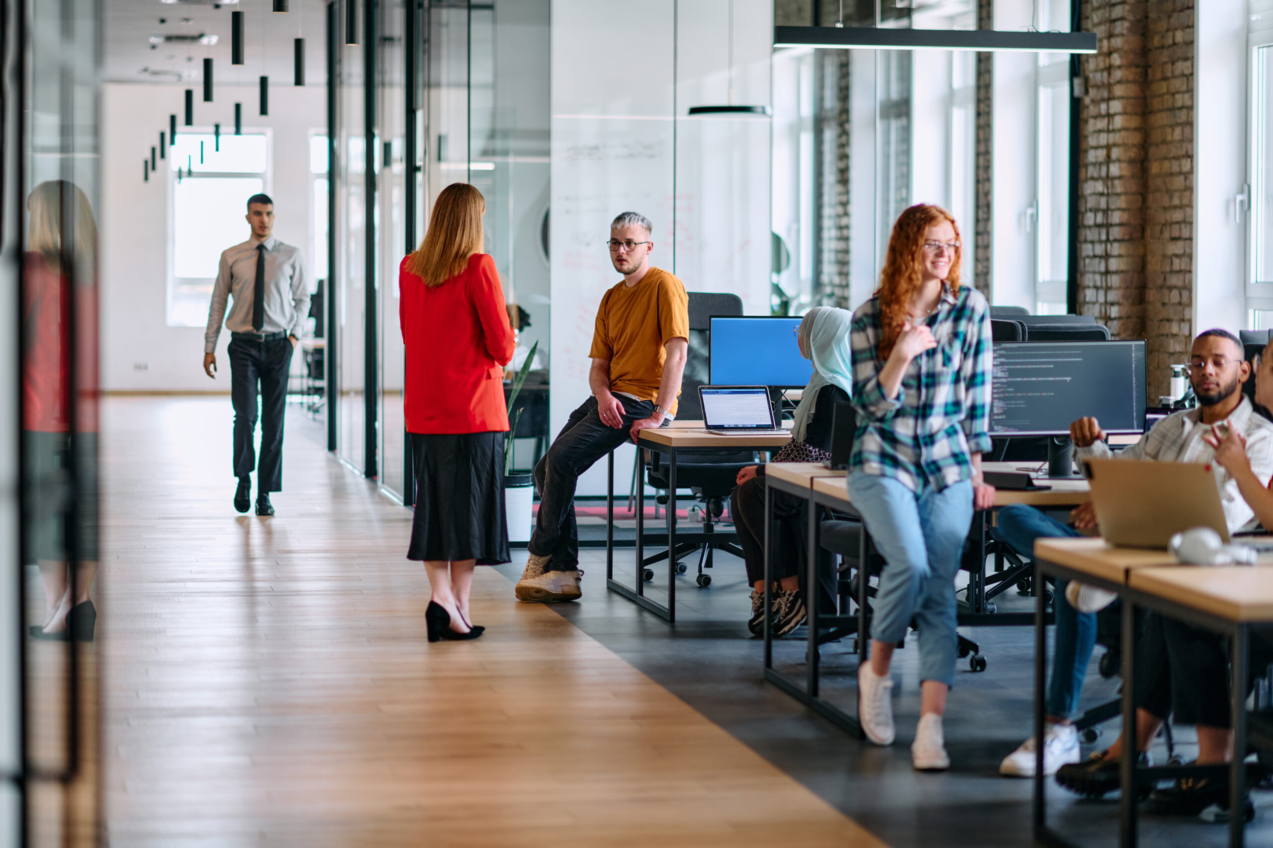 A diverse group of young business individuals congregates in a modern startup coworking center, embodying collaborative innovation and a dynamic atmosphere.